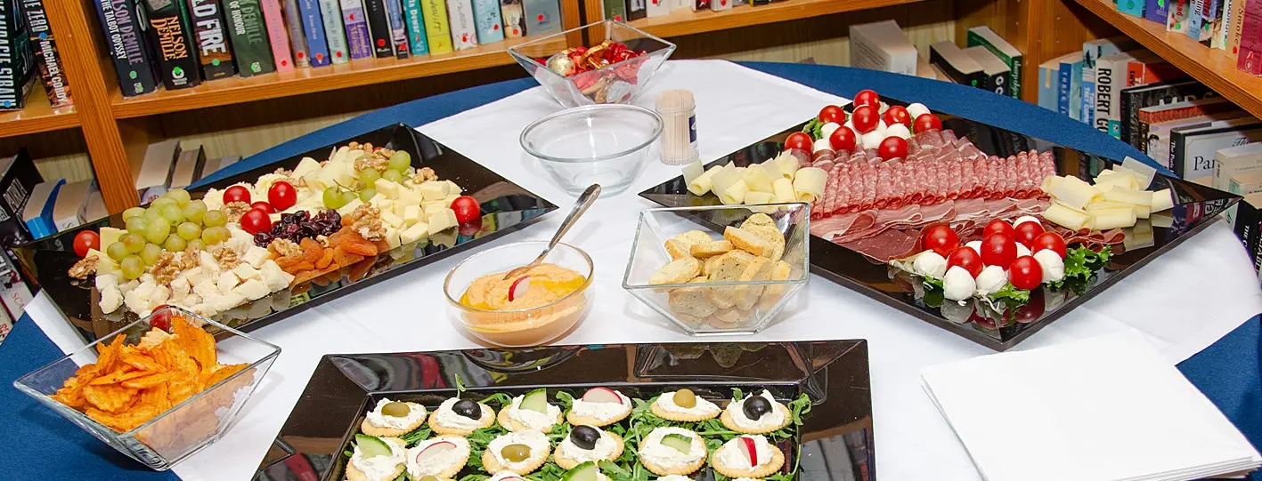 A table laid out with a tablecloth and platters of meat and cheese ready for the Centrepoint monthly apéro