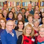Large group of Centrepoint volunteers in the library looking at the camera and smiling